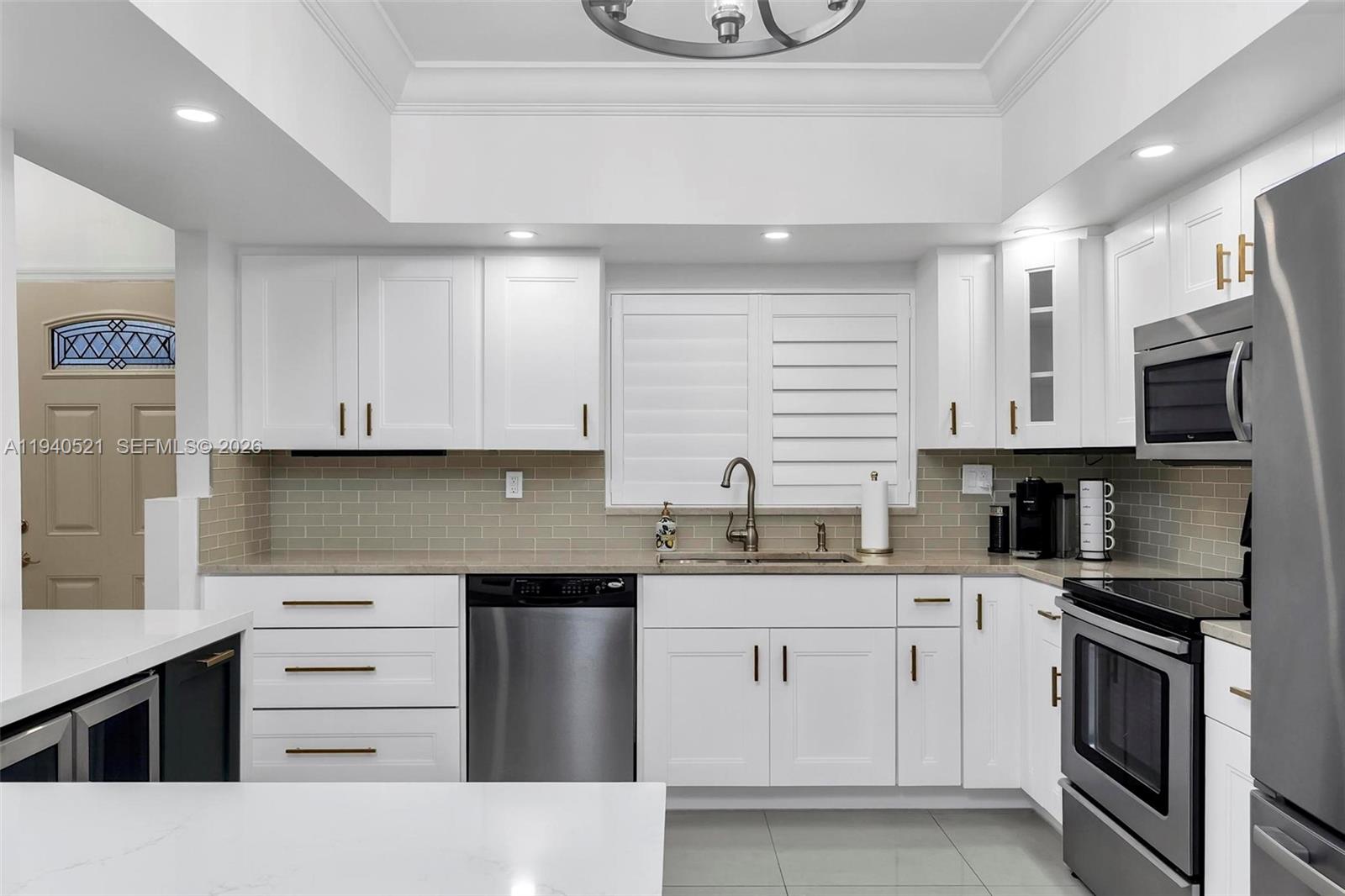 8898 Southwest 62nd Terrace, Unit 7F Miami, FL 33173 - Photo 18 of 66 a kitchen with granite countertop a sink stainless steel appliances and cabinets