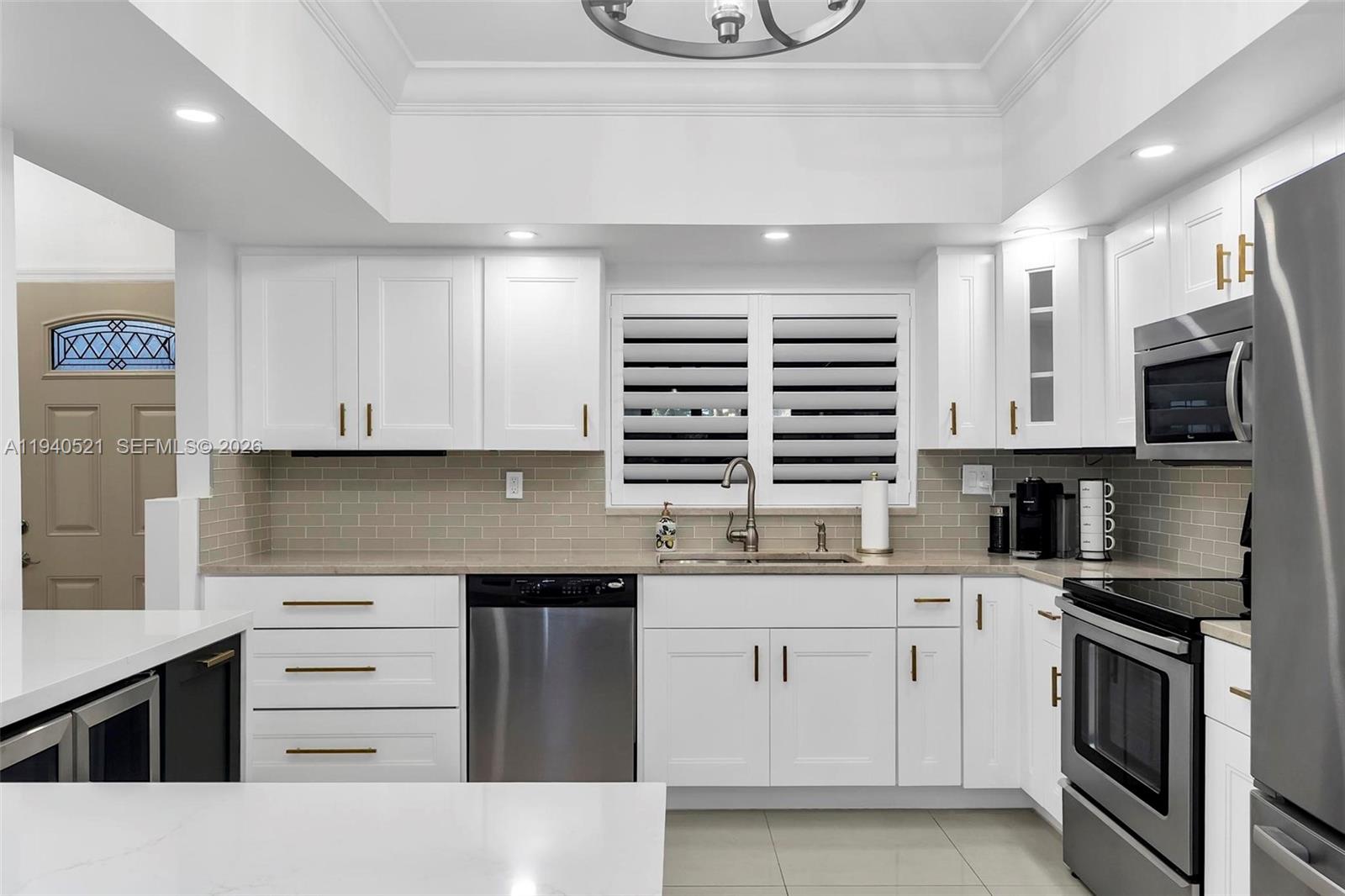 8898 Southwest 62nd Terrace, Unit 7F Miami, FL 33173 - Photo 19 of 66 a kitchen with stainless steel appliances granite countertop a sink and cabinets