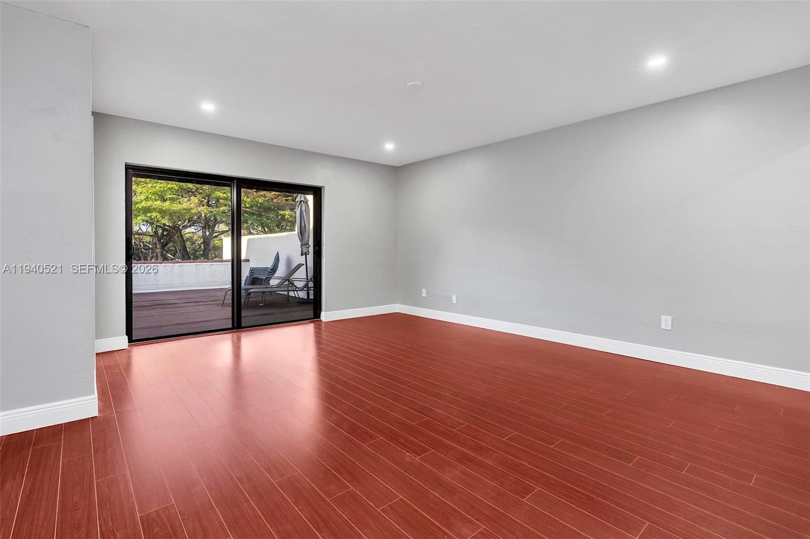 8898 Southwest 62nd Terrace, Unit 7F Miami, FL 33173 - Photo 42 of 66 a view of an empty room with wooden floor and a window