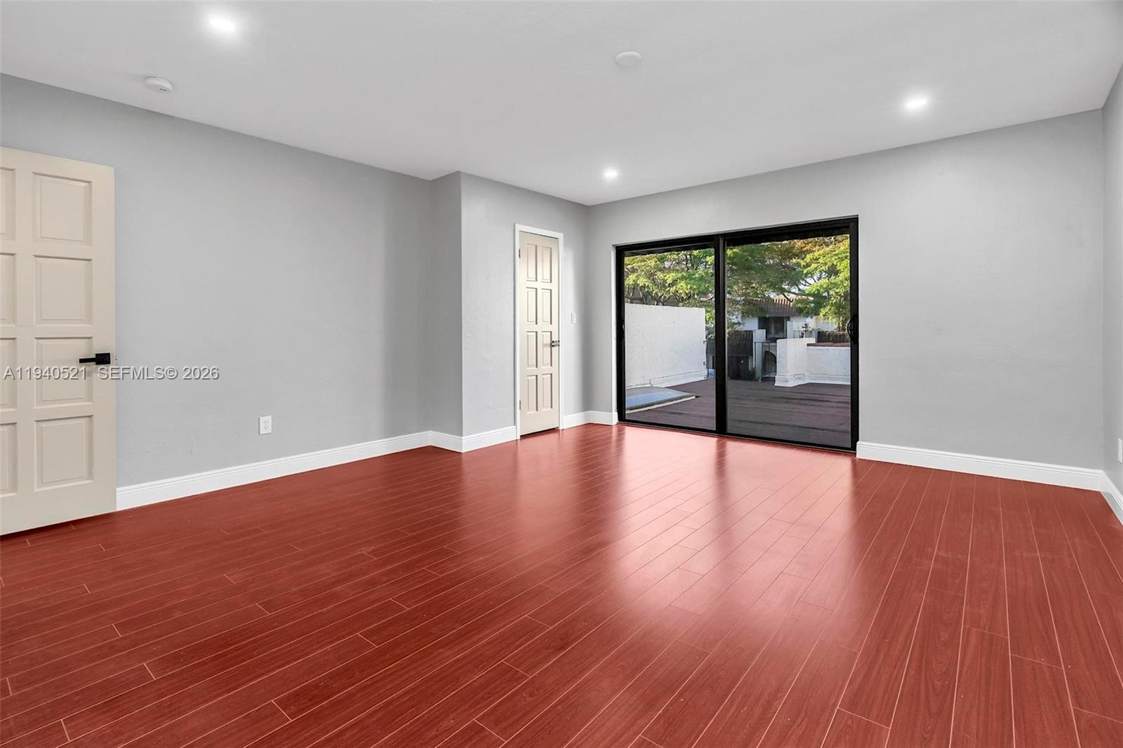 8898 Southwest 62nd Terrace, Unit 7F Miami, FL 33173 - Photo 43 of 66 a view of an empty room with wooden floor and a window