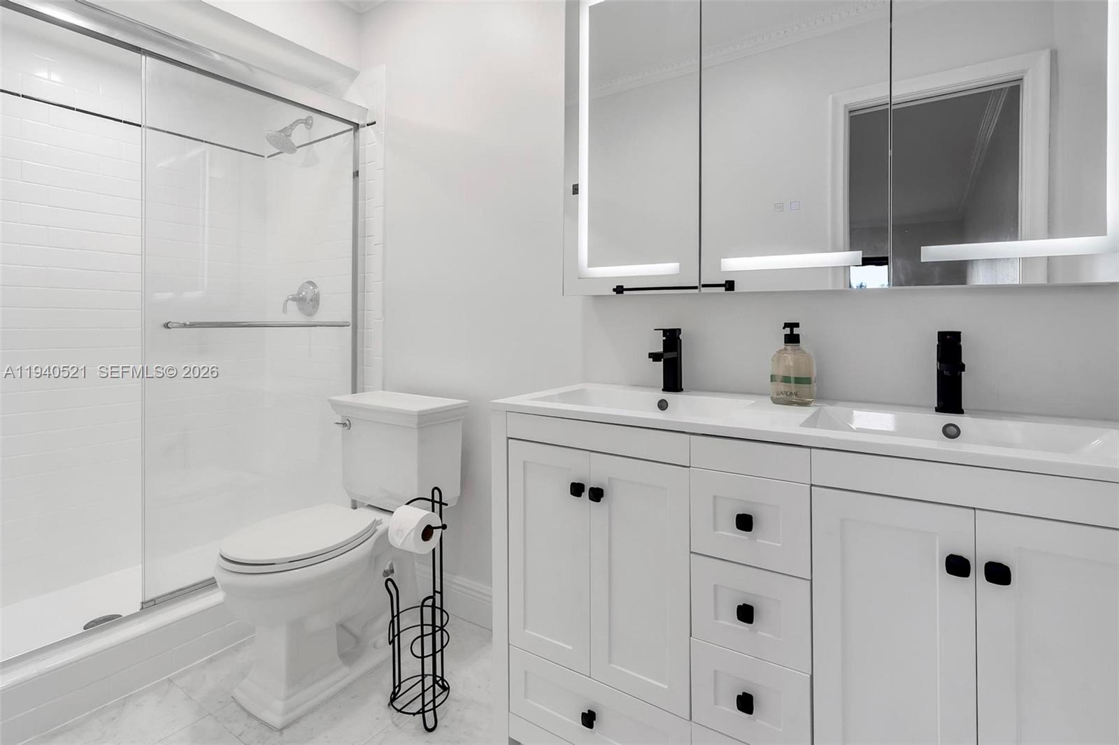 8898 Southwest 62nd Terrace, Unit 7F Miami, FL 33173 - Photo 59 of 66 a bathroom with a double vanity sink mirror and toilet