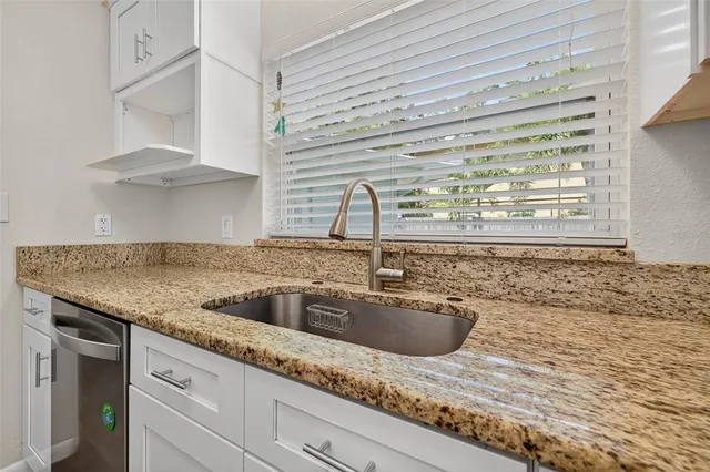 a kitchen with granite countertop a sink and a window