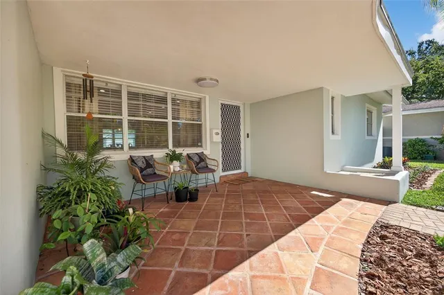a view of a porch with chairs and potted plants