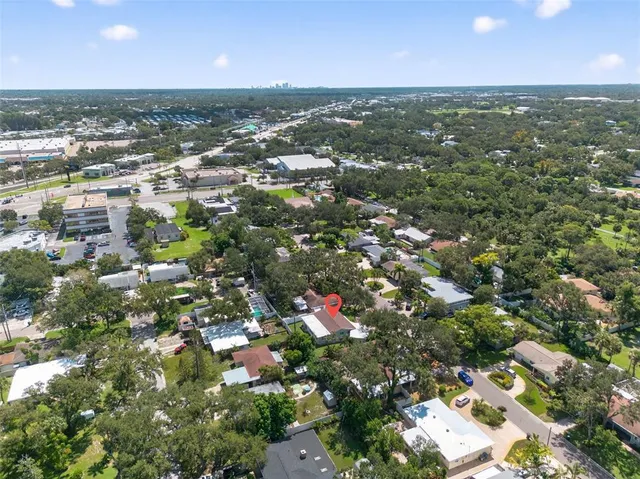 an aerial view of residential houses with outdoor space and trees