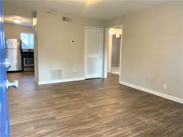 a view of a room with wooden floor and a bathroom