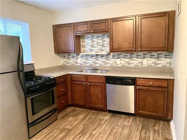 a kitchen with stainless steel appliances granite countertop a stove a sink and a refrigerator