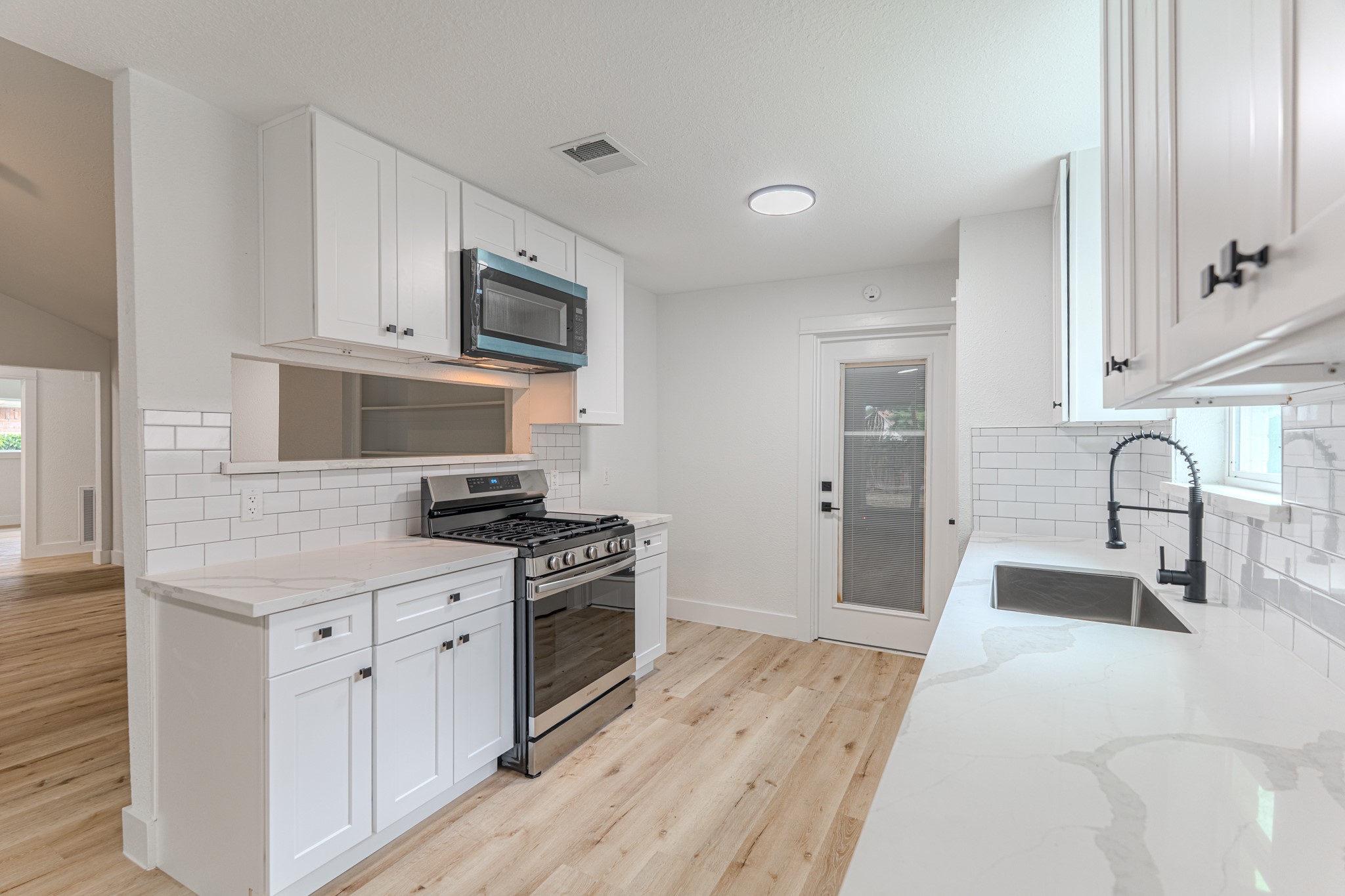 3702 Acorn Way Lane Spring, TX 77389 - Photo 15 of 38 a kitchen with stainless steel appliances granite countertop a stove top oven a sink dishwasher and a microwave with wooden floor