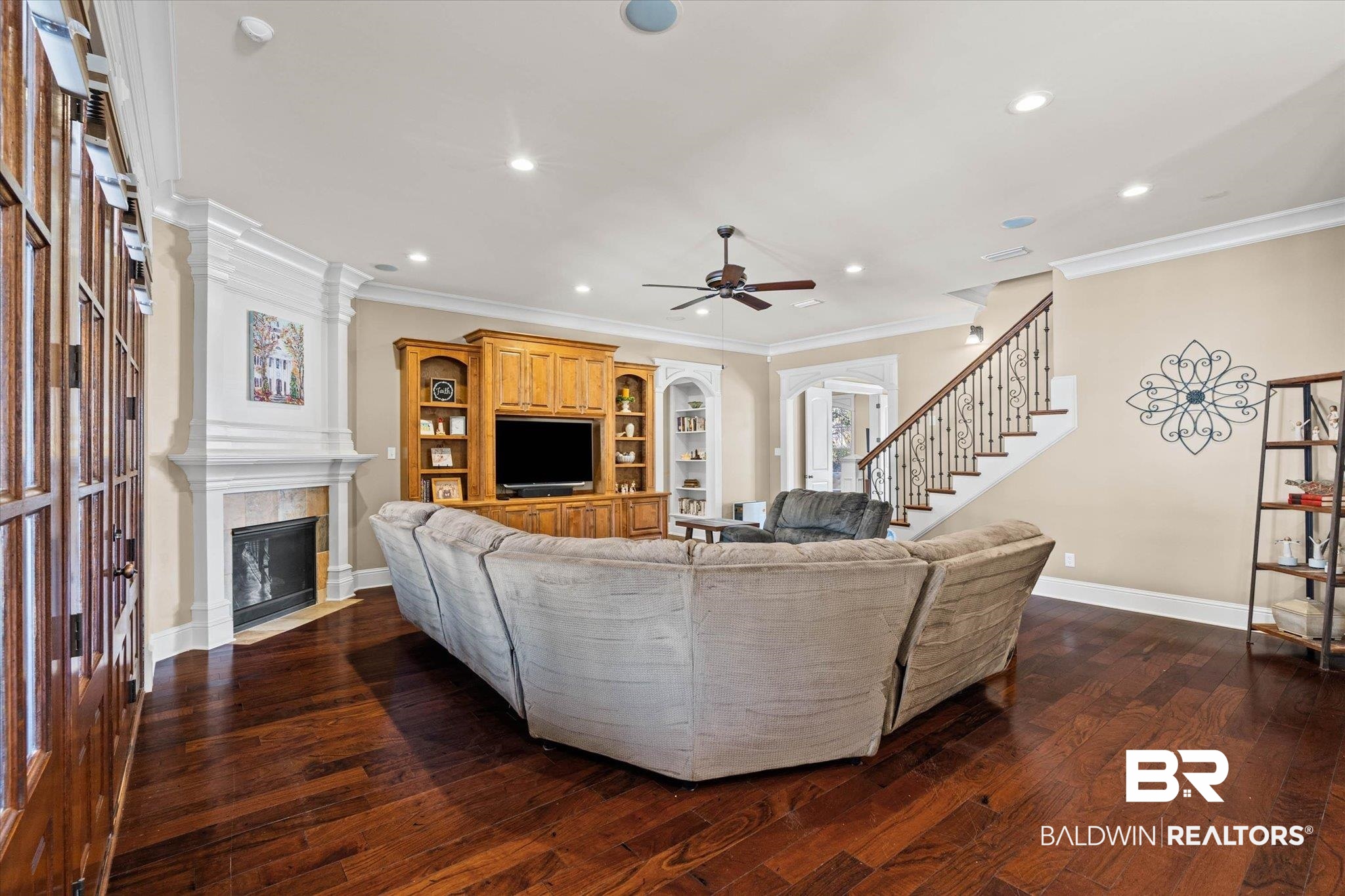 7676 Rockstone Lane Mobile, AL 36695 - Photo 10 of 47 Living area with dark wood finished floors, a tiled fireplace, recessed lighting, ornamental molding, and a ceiling fan