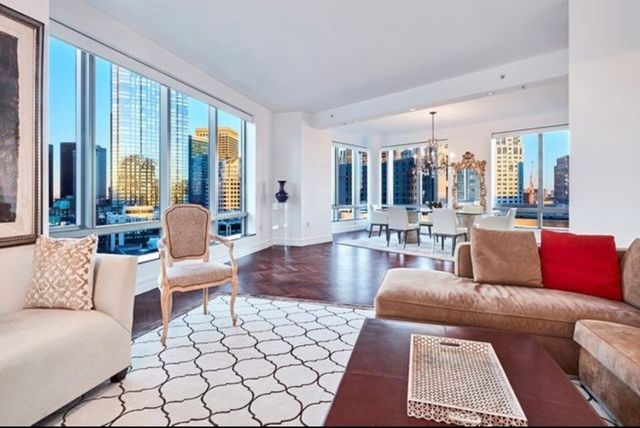 a living room with furniture and large windows