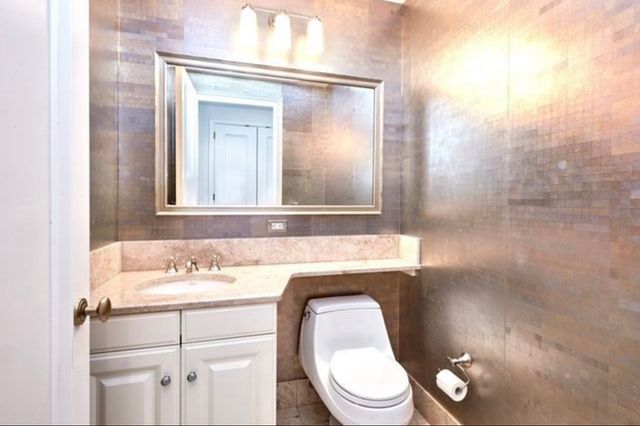 a bathroom with a toilet sink and mirror