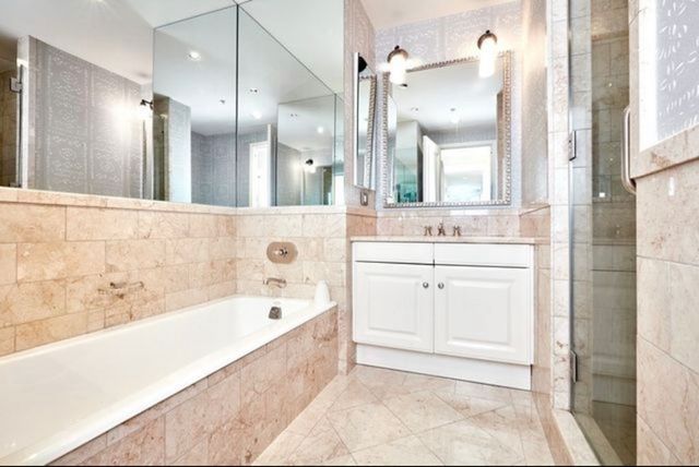 a bathroom with a bathtub a sink a vanity and a shower