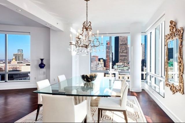 a dining room with furniture a chandelier and wooden floor