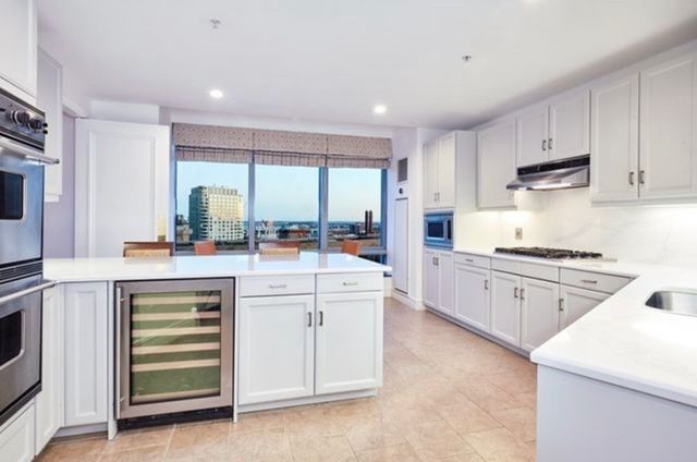a kitchen with white cabinets and white appliances