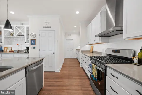 a kitchen with stainless steel appliances a sink stove and cabinets