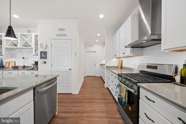 a kitchen with stainless steel appliances a sink stove and cabinets