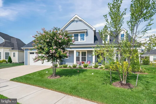 a front view of a house with a garden and trees