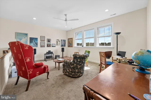 a living room with furniture kitchen view and a large window