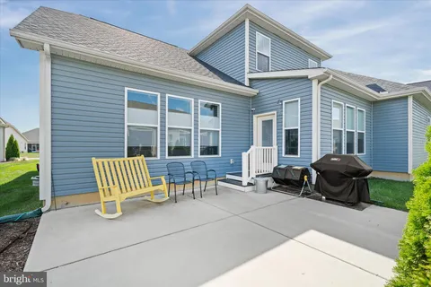 a front view of a house with porch and chairs