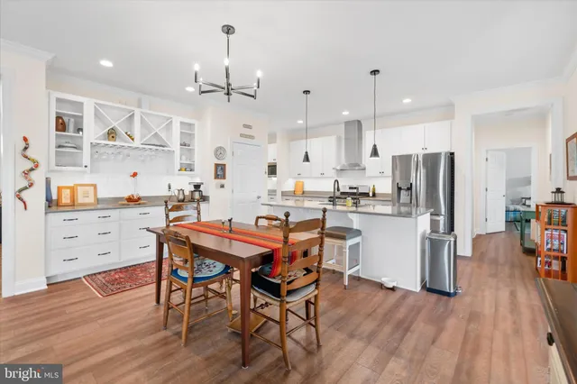 a kitchen with stainless steel appliances kitchen island a refrigerator and a wooden cabinets