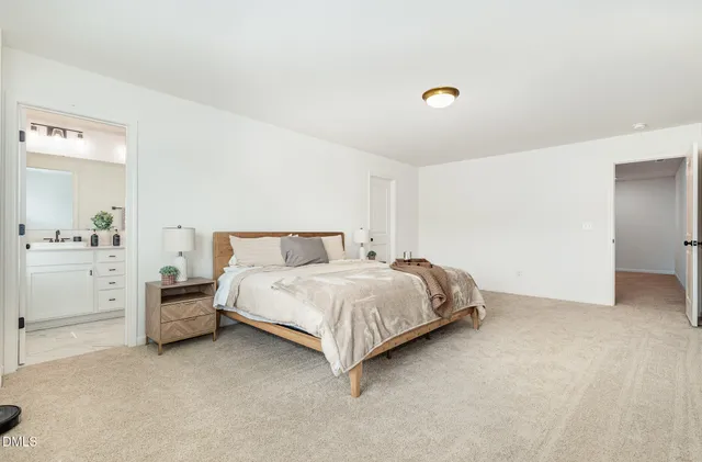 a spacious bedroom with a bed and dresser