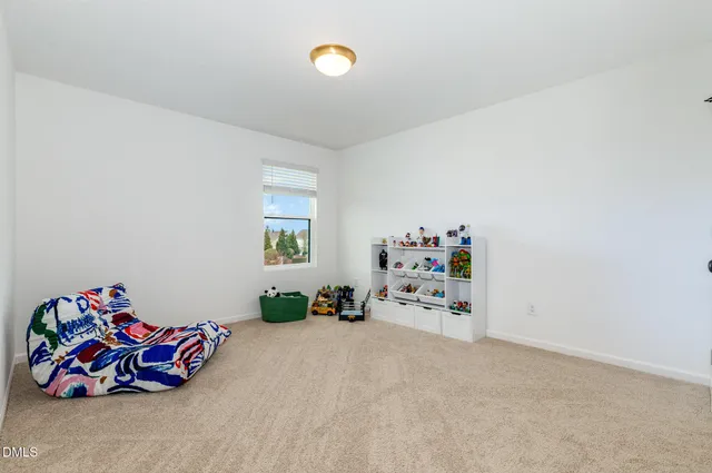 a bedroom with a bed and a flat tv screen on the dresser