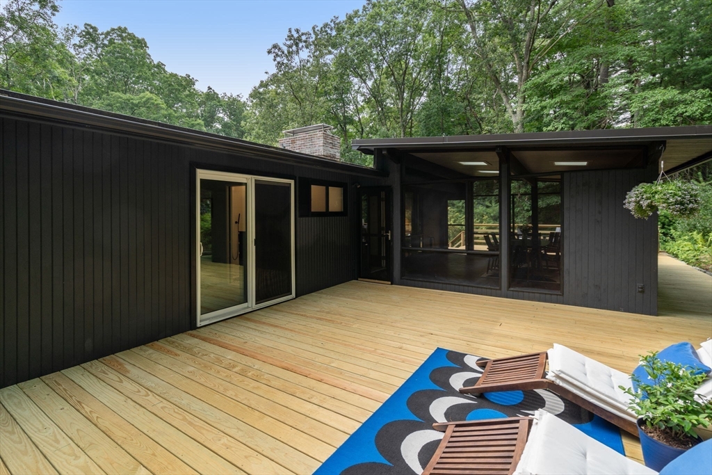 5 Apple Street Sherborn, MA 01770 - Photo 29 of 36 a backyard of a house with wooden fence and potted plants