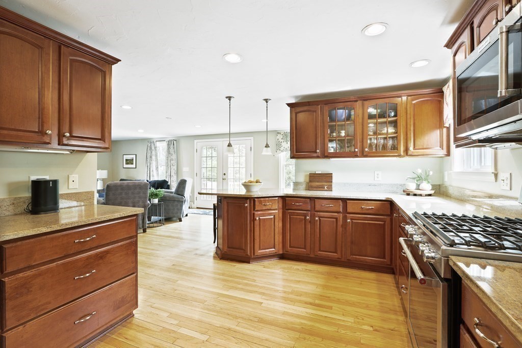 18 Moore Street Natick, MA 01760 - Photo 3 of 42 a kitchen with stainless steel appliances kitchen island granite countertop a stove top oven a sink dishwasher cabinets and granite countertops with wooden floor