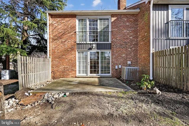 a backyard of a house with large trees and brick walls