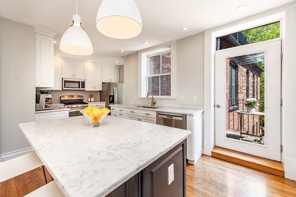 a kitchen with a sink a stove and wooden floor
