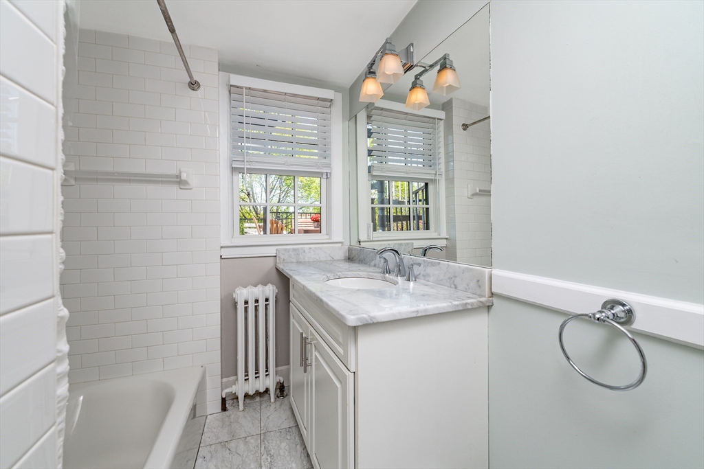 13 Harvard Street, Unit 3 Boston, MA 02129 - Photo 9 of 14 a bathroom with a granite countertop sink and a window