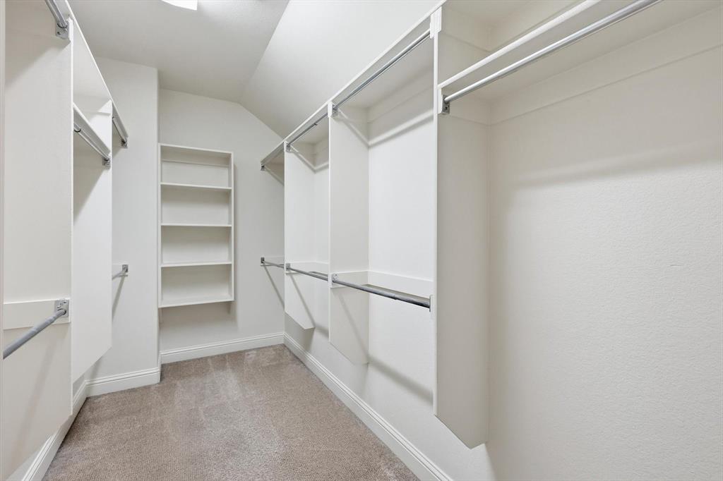 516 Sandy Lane Flower Mound, TX 75022 - Photo 26 of 38 Walk-in closet featuring built-in shelving, white cabinetry, chrome hanging rods, and light-colored carpet flooring