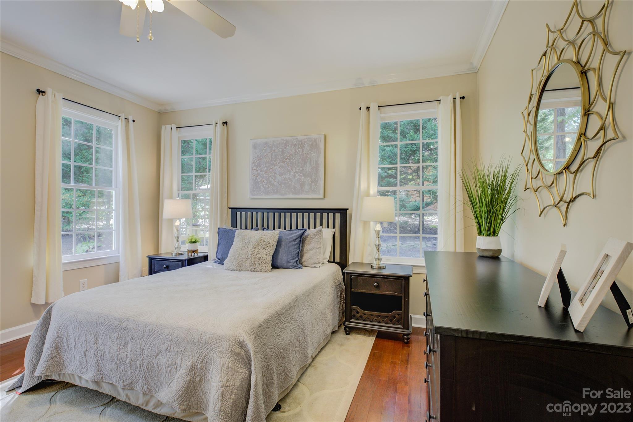 12017 Forest Home Drive Fort Mill, SC 29708 - Photo 20 of 44 a bedroom with a bed potted plant on the dresser and a chandelier