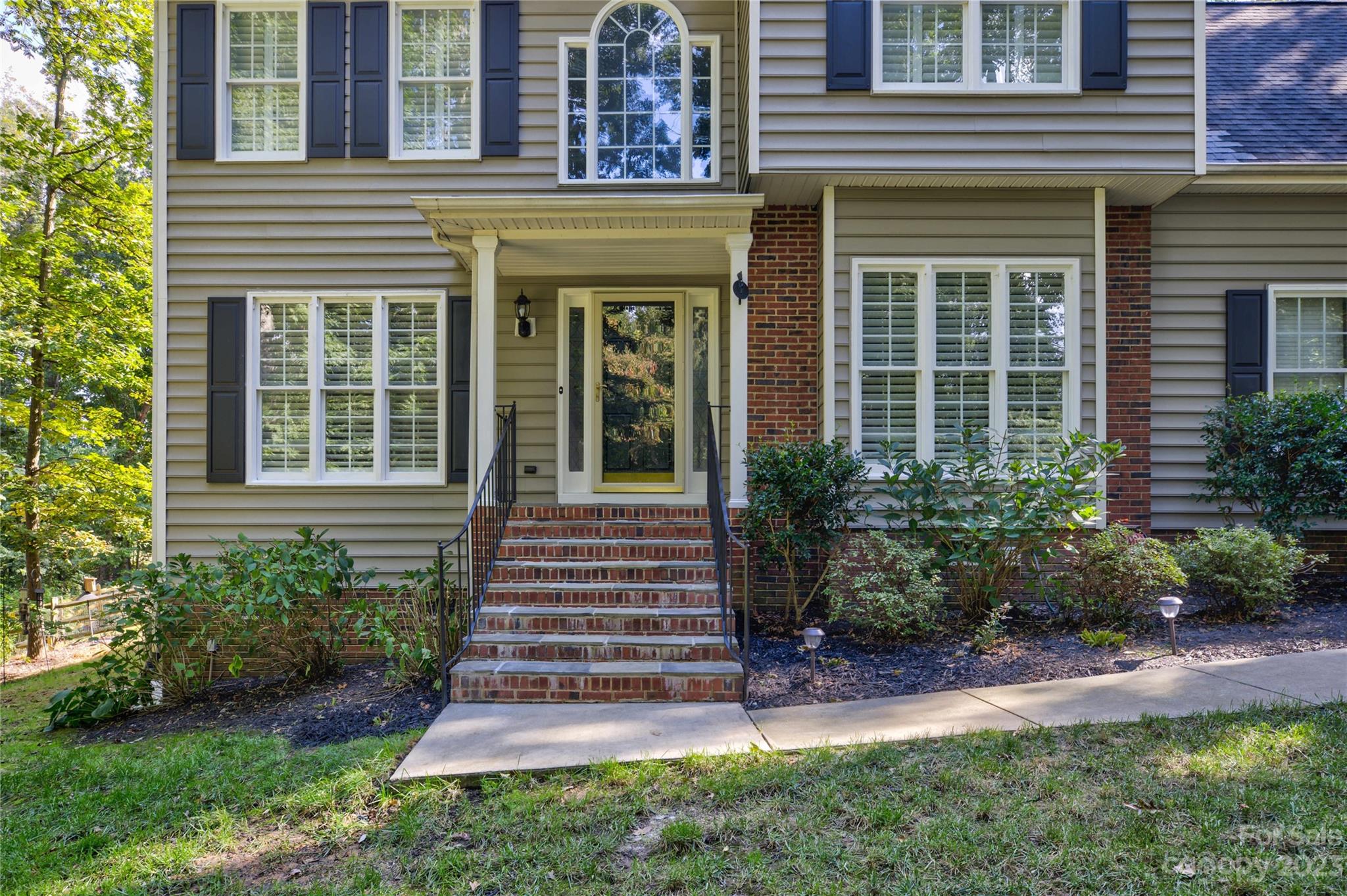 12017 Forest Home Drive Fort Mill, SC 29708 - Photo 5 of 44 a view of a house with potted plants and a bench
