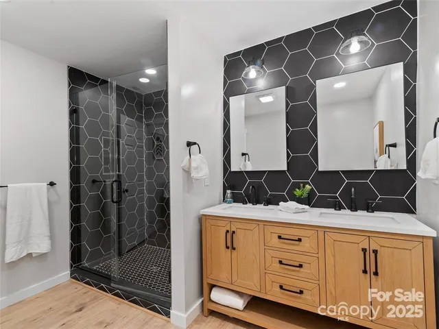 a bathroom with a granite countertop sink a mirror and shower