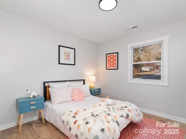 a bedroom with a bed and painting on the wall
