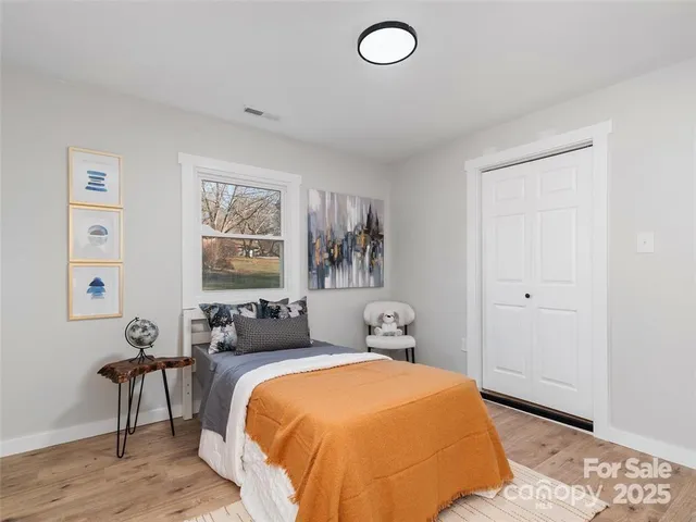 a bedroom with a bed and wooden floor