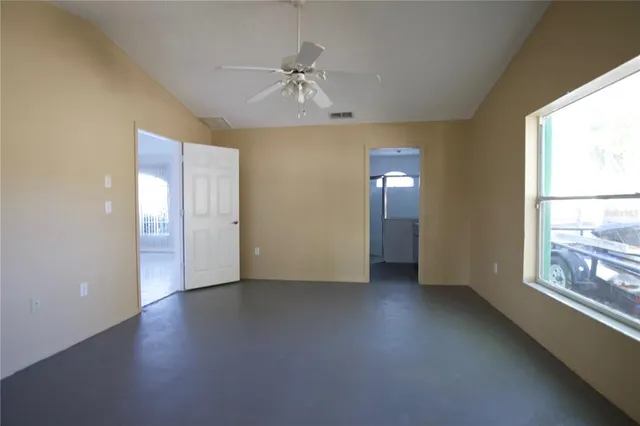 a bedroom with a bed couch and a ceiling fan