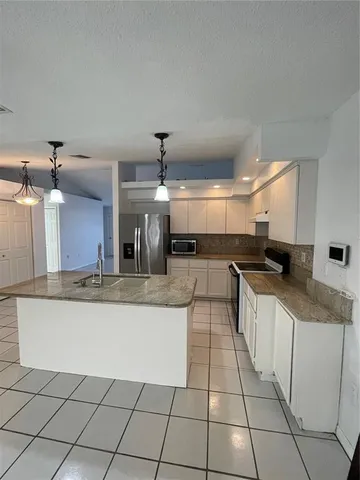 a large kitchen with granite countertop a large counter top and sink