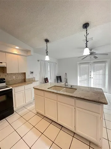 a kitchen with granite countertop white cabinets and white appliances