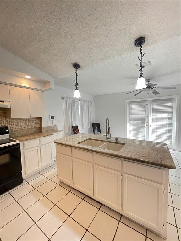 11322 Topaz Street Spring Hill, FL 34608 - Photo 13 of 41 a kitchen with granite countertop white cabinets and white appliances