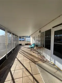 a view of a hallway with a tv and couches