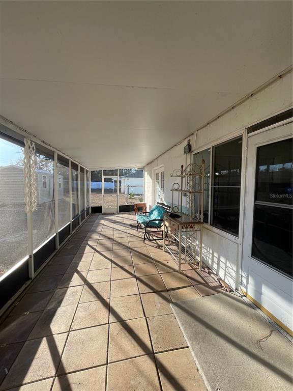 11322 Topaz Street Spring Hill, FL 34608 - Photo 24 of 41 a view of a hallway with a tv and couches