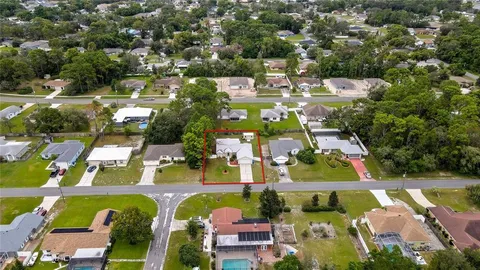an aerial view of residential houses with outdoor space and swimming pool
