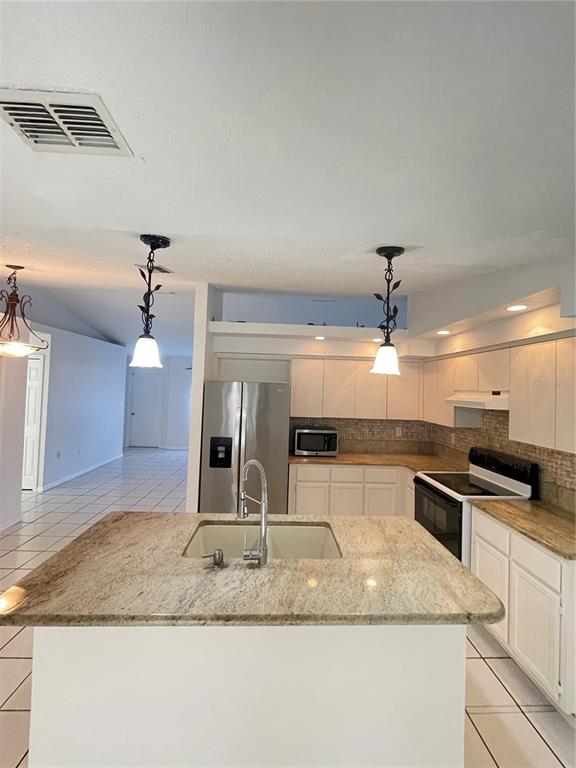 11322 Topaz Street Spring Hill, FL 34608 - Photo 4 of 41 a kitchen with kitchen island a sink and stove