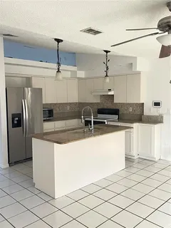 a kitchen with stainless steel appliances granite countertop a sink and a refrigerator