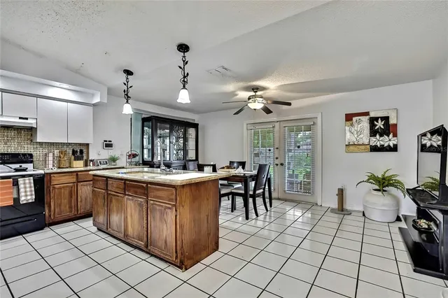a kitchen with kitchen island granite countertop a sink a counter top space appliances and cabinets