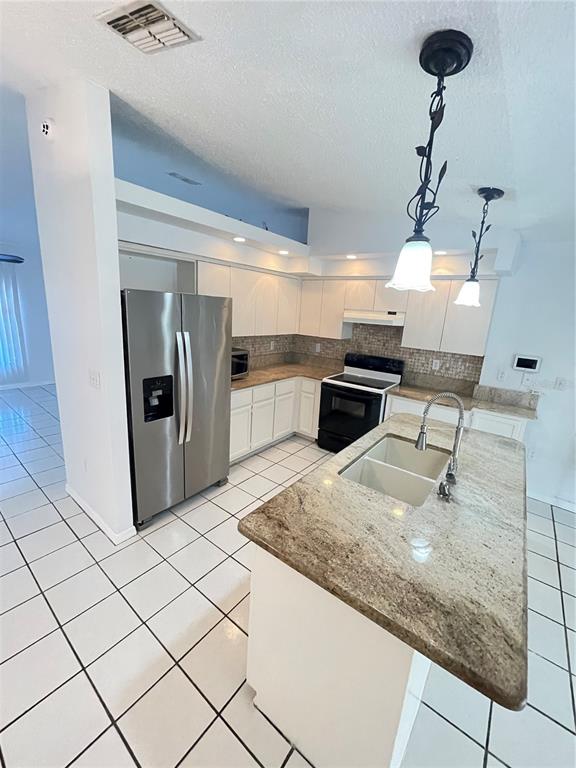11322 Topaz Street Spring Hill, FL 34608 - Photo 6 of 41 a kitchen with stainless steel appliances granite countertop a sink and a stove