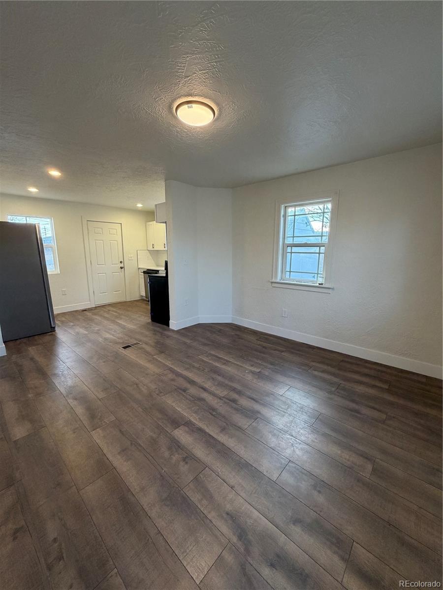 54 East Cornell Avenue Englewood, CO 80113 - Photo 3 of 10 an empty room with wooden floor and windows