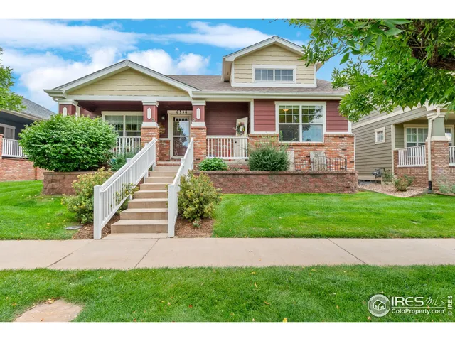 a front view of a house with a yard and potted plants