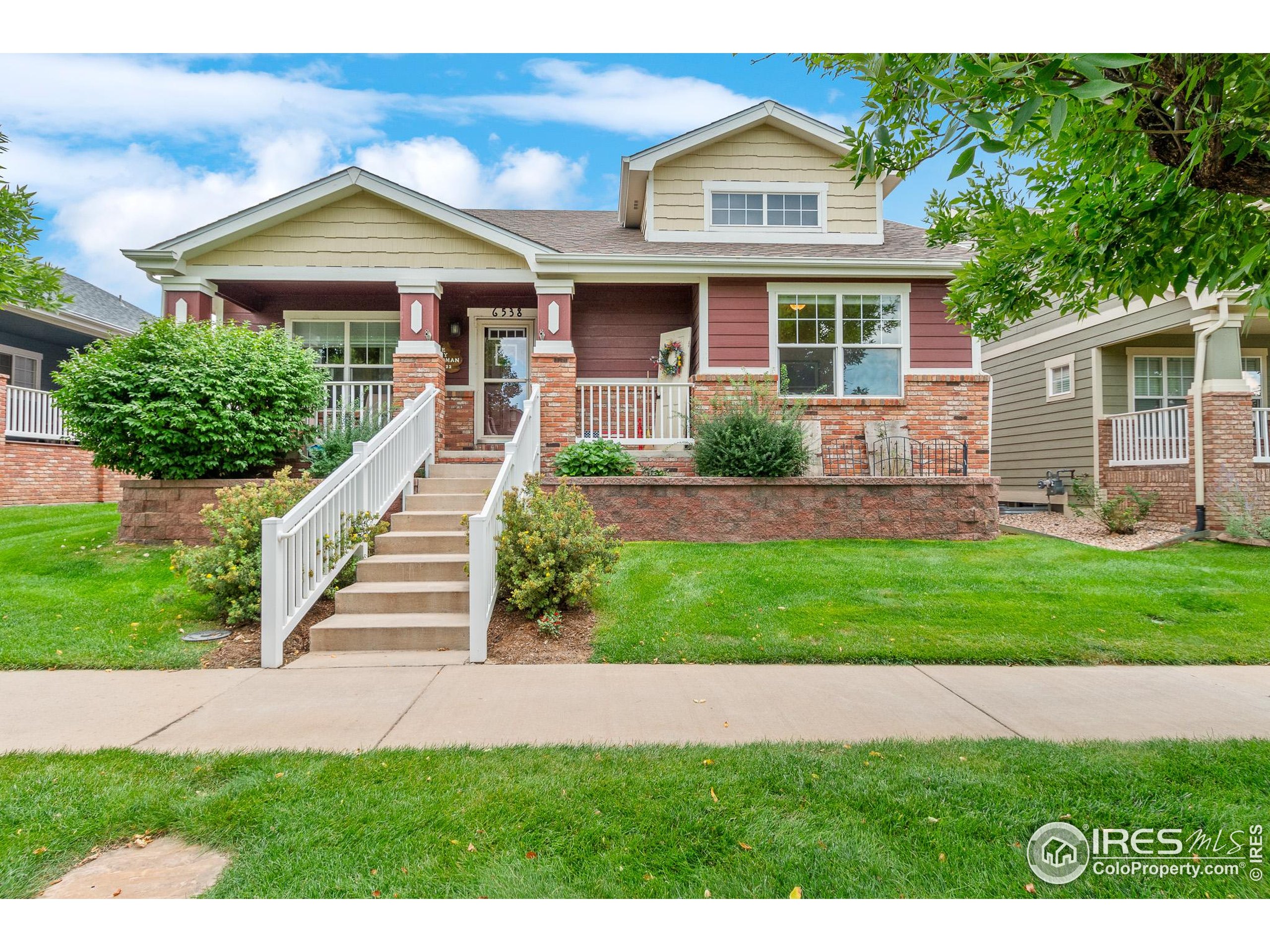 a front view of a house with a yard and potted plants